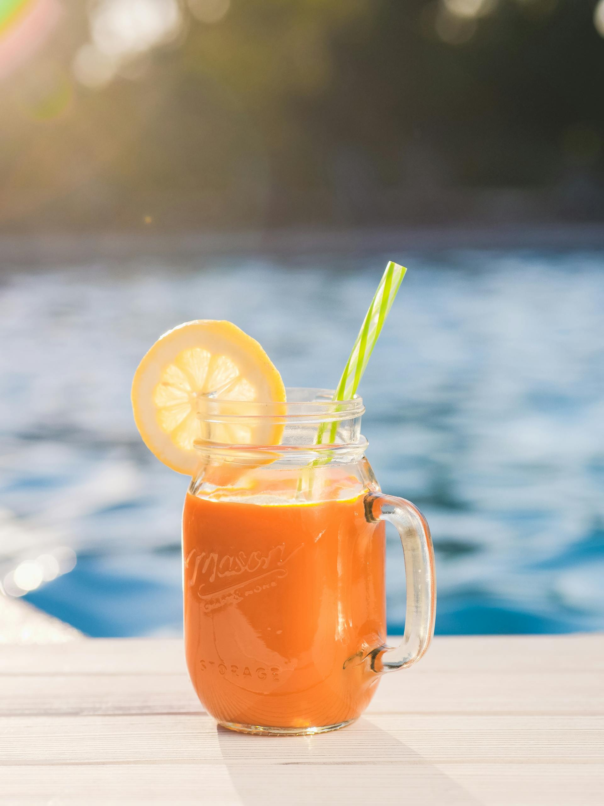 Augen-Smoothie mit Strohhalm Smoothie aus Karotte, Apfel, Ingwer, Orange im Glas mit Strohhalm